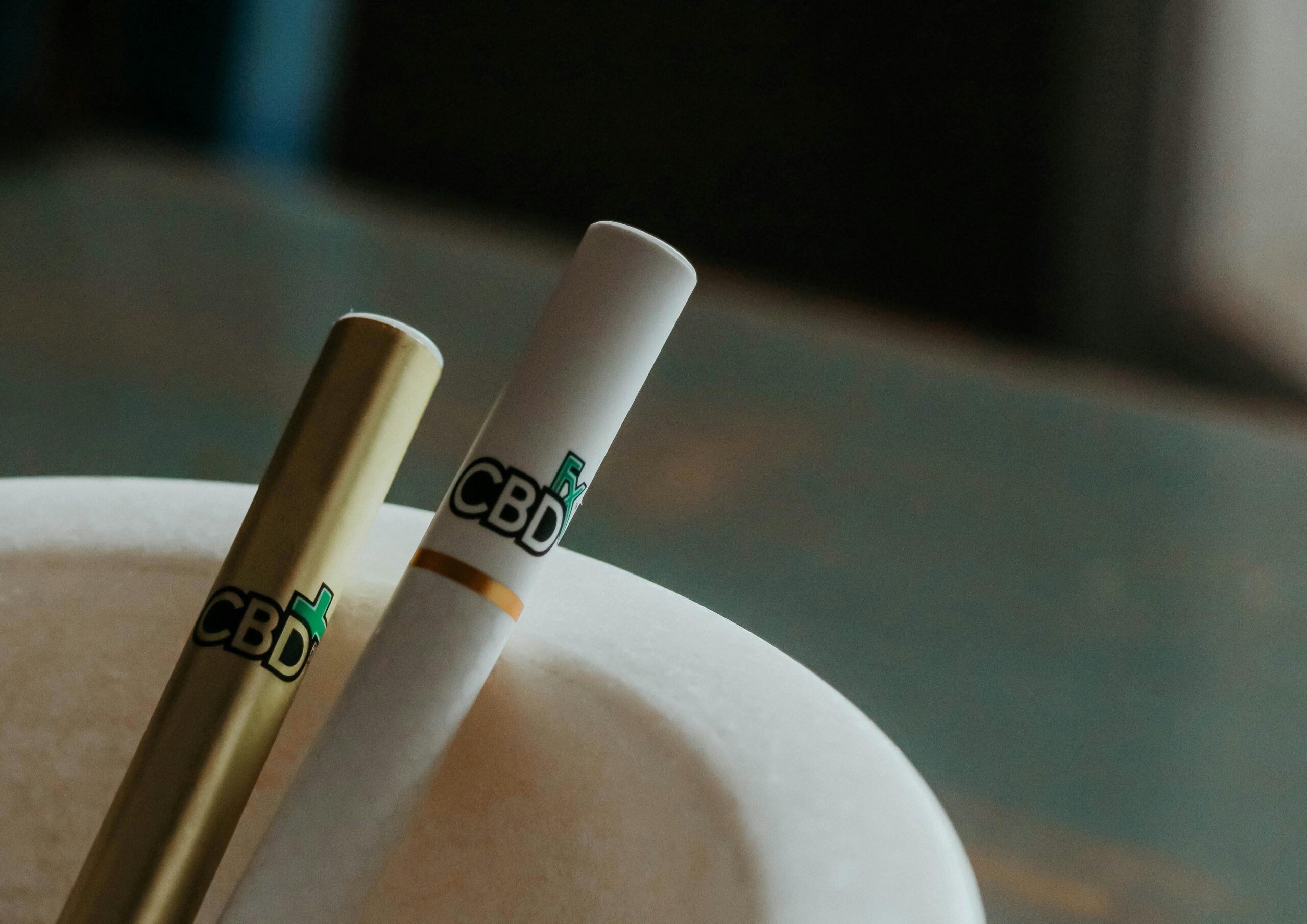 A detailed close-up of CBD vape pens resting in an elegant ashtray.